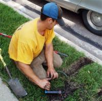 a tech is fixing a broken sprinkler line